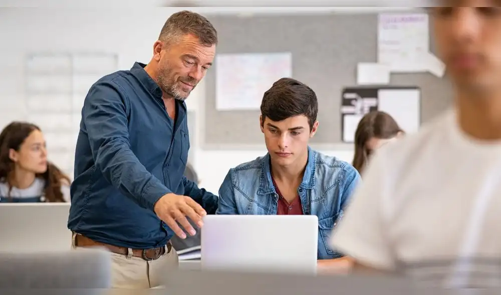 profesor con estudiante en la computadora